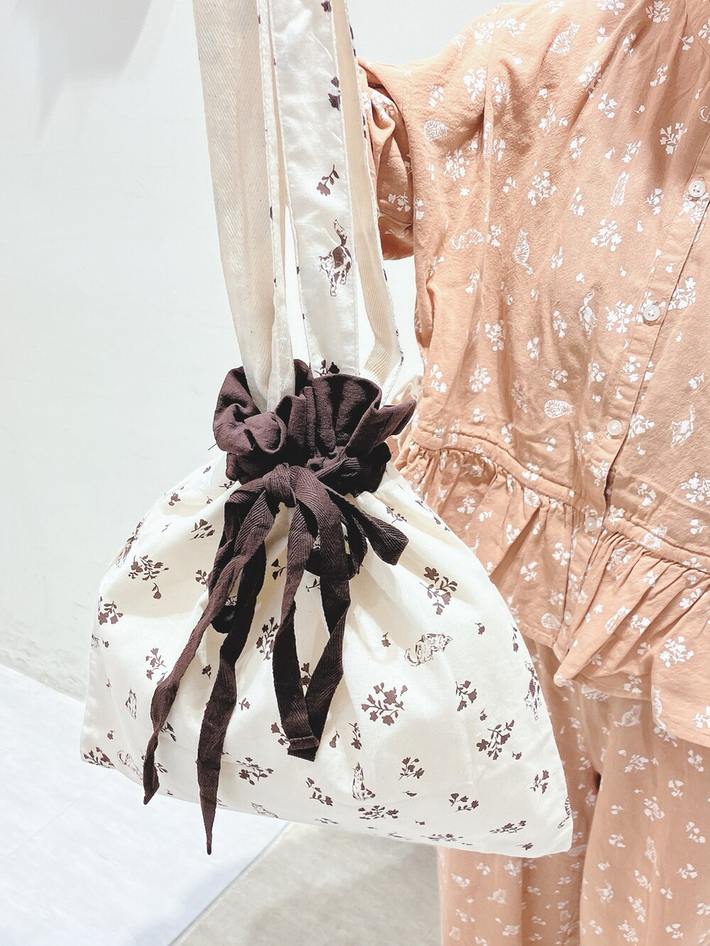 オレンジ系のシャツ/ブラウス、オレンジ系のパンツ、ホワイト系のバッグを着用したレディースの秋コーディネートの5枚目の写真