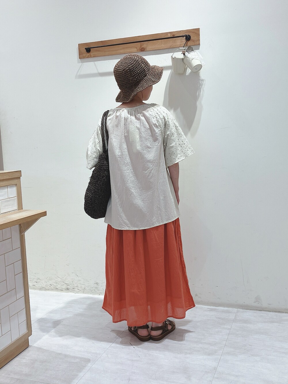 ベージュ系のシャツ/ブラウス、レッド系のワンピース、ブラウン系のハンドバッグを着用したレディースの春コーディネートの3枚目の写真