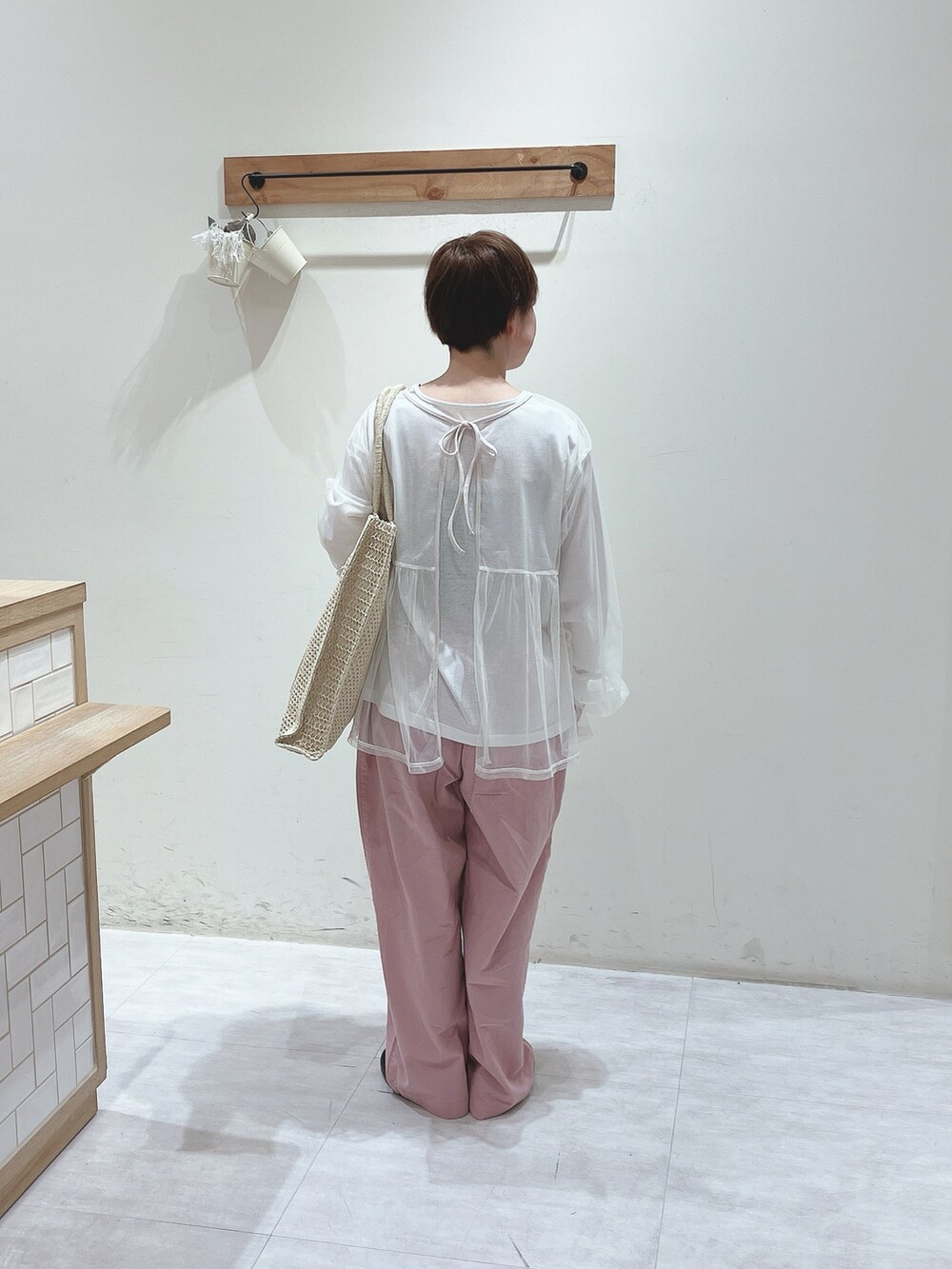 ホワイト系のTシャツ/カットソー、ホワイト系のハンドバッグ、ピンク系のパンツを着用したレディースの春コーディネートの3枚目の写真