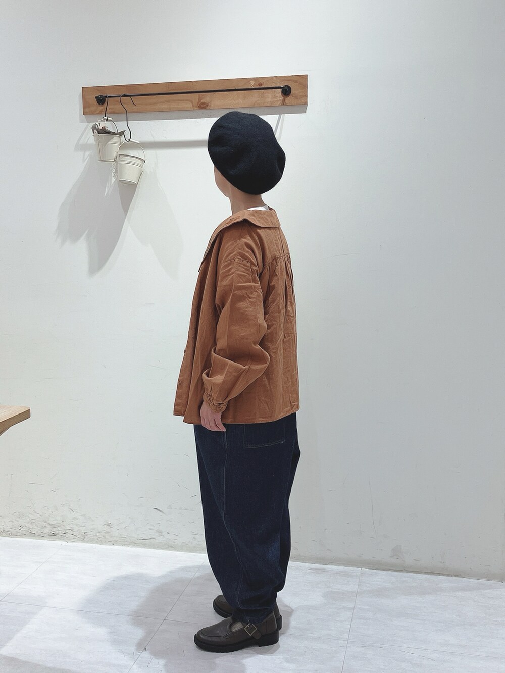 オレンジ系のシャツ/ブラウス、ブルー系のサロペット/オーバーオール、ブラウン系のドレスシューズを着用したレディースの秋コーディネートの2枚目の写真