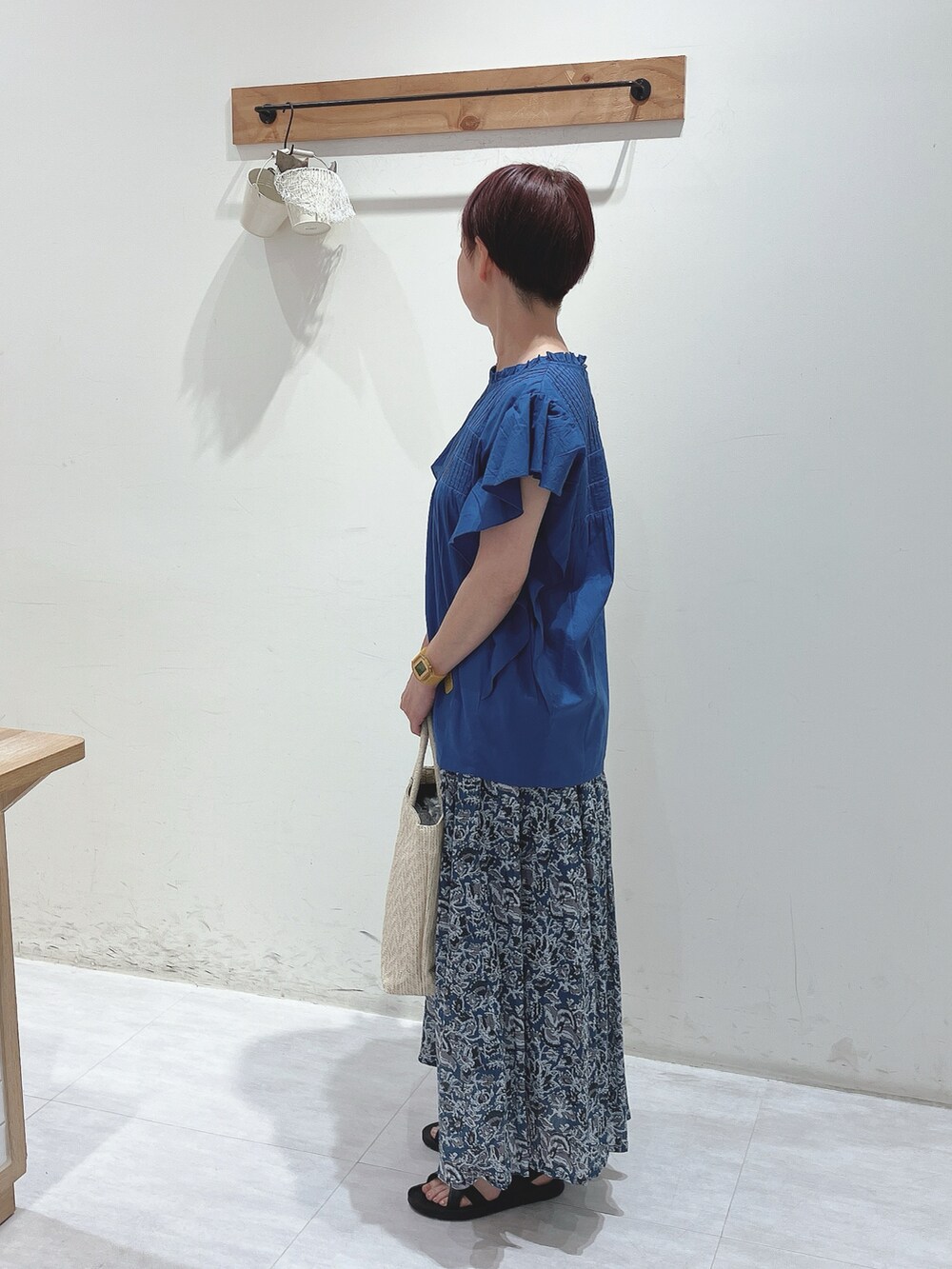 ホワイト系のハンドバッグ、ブルー系のシャツ/ブラウス、ブルー系のスカートを着用したレディースの夏コーディネートの2枚目の写真