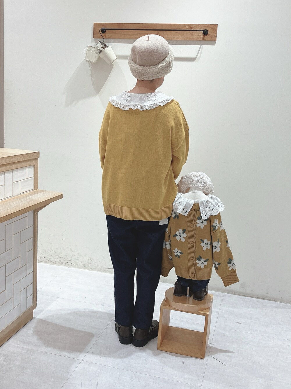 ホワイト系のシャツ/ブラウス、イエロー系のニット/セーター、ブルー系のデニムパンツを着用したレディースの秋コーディネートの2枚目の写真