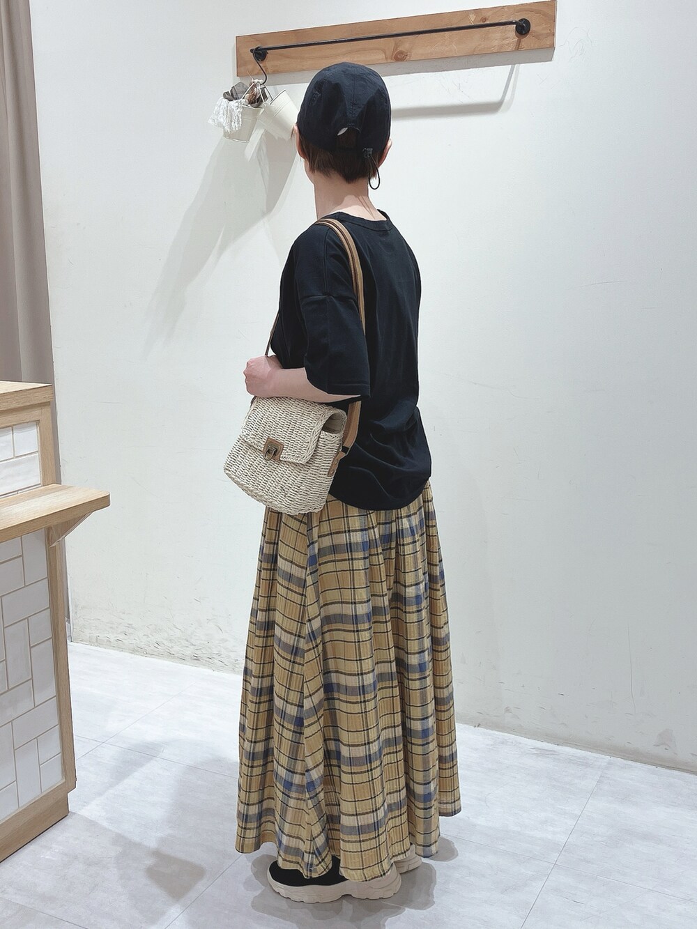 ブラック系のTシャツ/カットソー、ベージュ系のかごバッグ、イエロー系のスカートを着用したレディースの春コーディネートの2枚目の写真