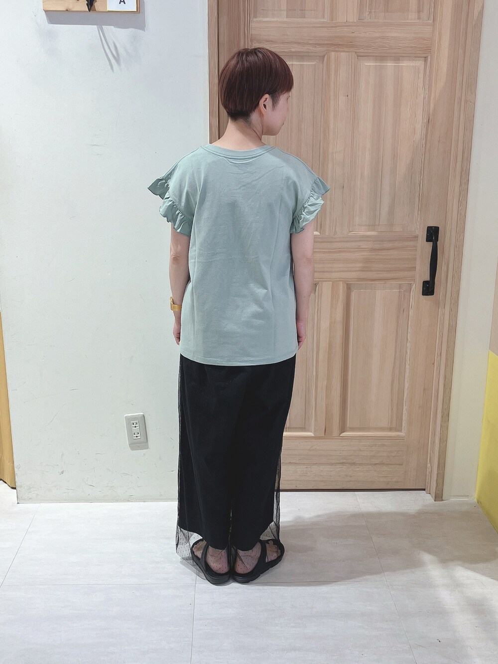 グリーン系のTシャツ/カットソー、ブラック系のその他パンツ、ブラック系のサンダルを着用したレディースの夏コーディネートの3枚目の写真