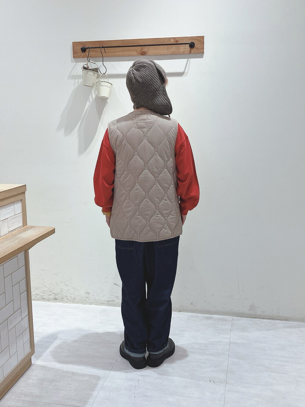 ベージュ系のその他アウター、レッド系のスウェット、ブルー系のデニムパンツを着用したレディースの秋コーディネートの3枚目の写真