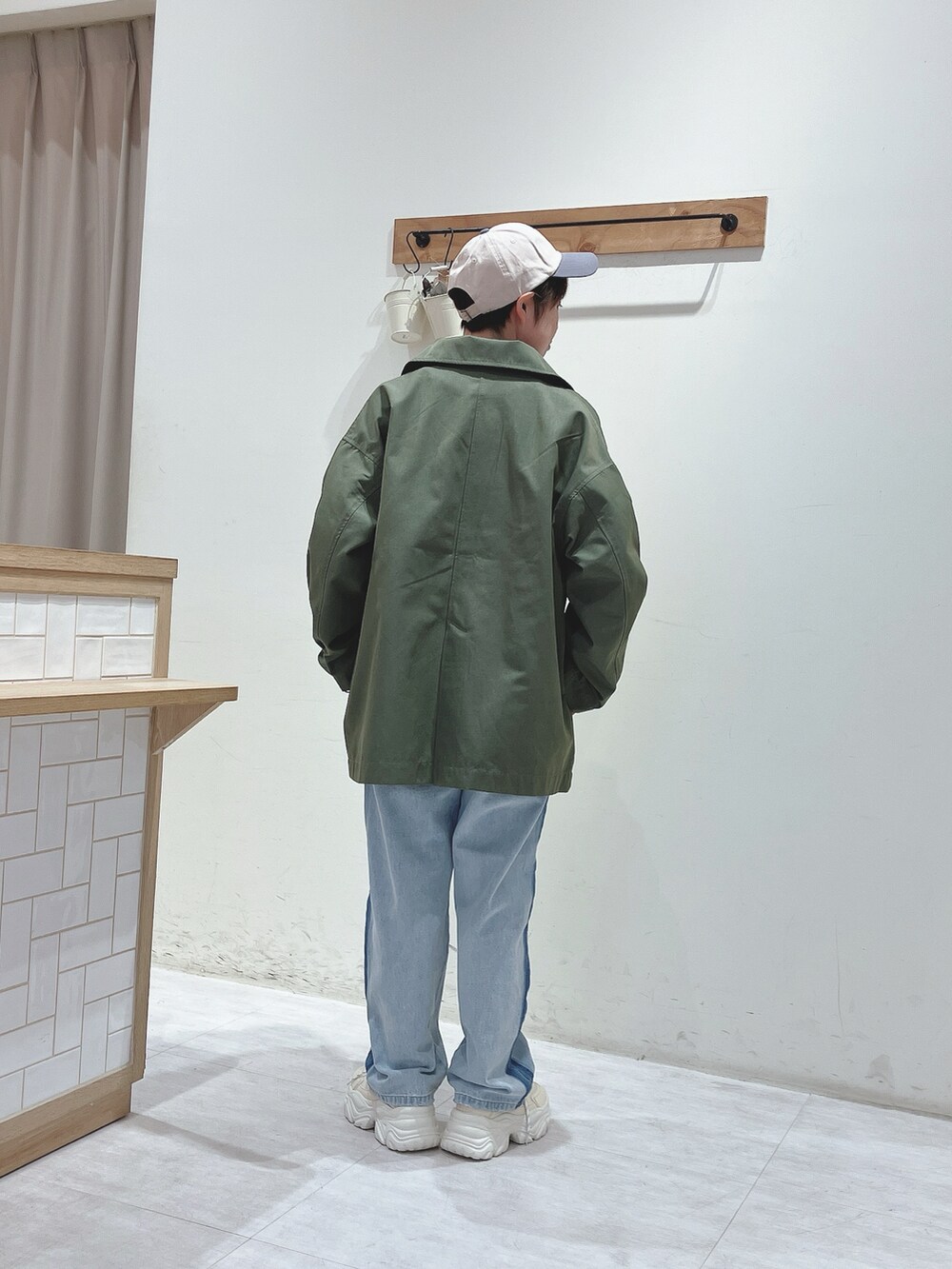 グリーン系のその他アウター、グリーン系のTシャツ/カットソー、ブルー系のデニムパンツを着用したレディースの冬コーディネートの3枚目の写真