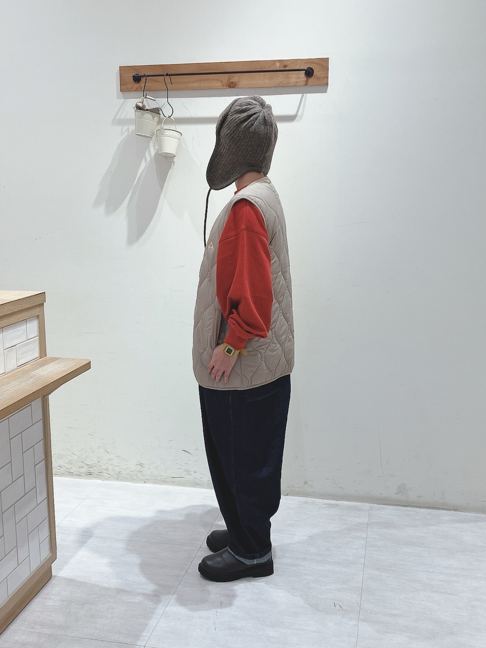 ベージュ系のその他アウター、レッド系のスウェット、ブルー系のデニムパンツを着用したレディースの秋コーディネートの2枚目の写真