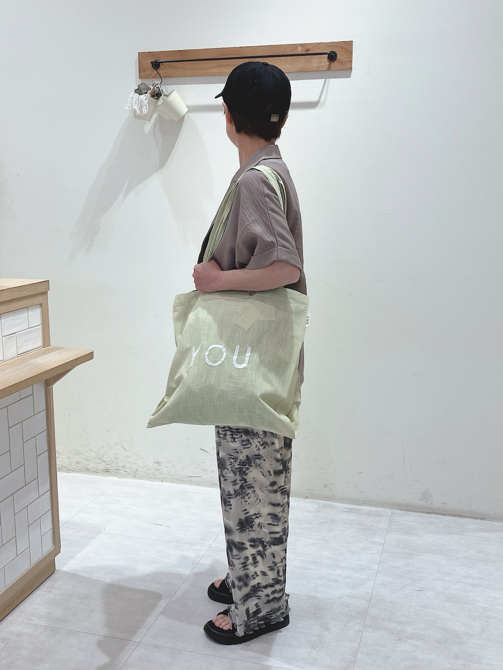 ブラウン系のシャツ/ブラウス、グリーン系のハンドバッグ、ホワイト系のTシャツ/カットソーを着用したレディースの春コーディネートの2枚目の写真