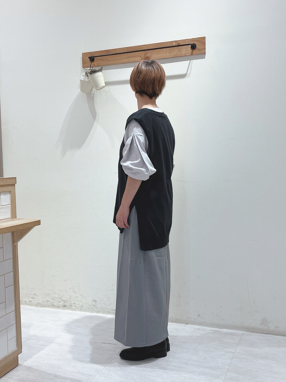 グレー系のニット/セーター、グレー系のTシャツ/カットソー、グレー系のスカートを着用したレディースの秋コーディネートの2枚目の写真