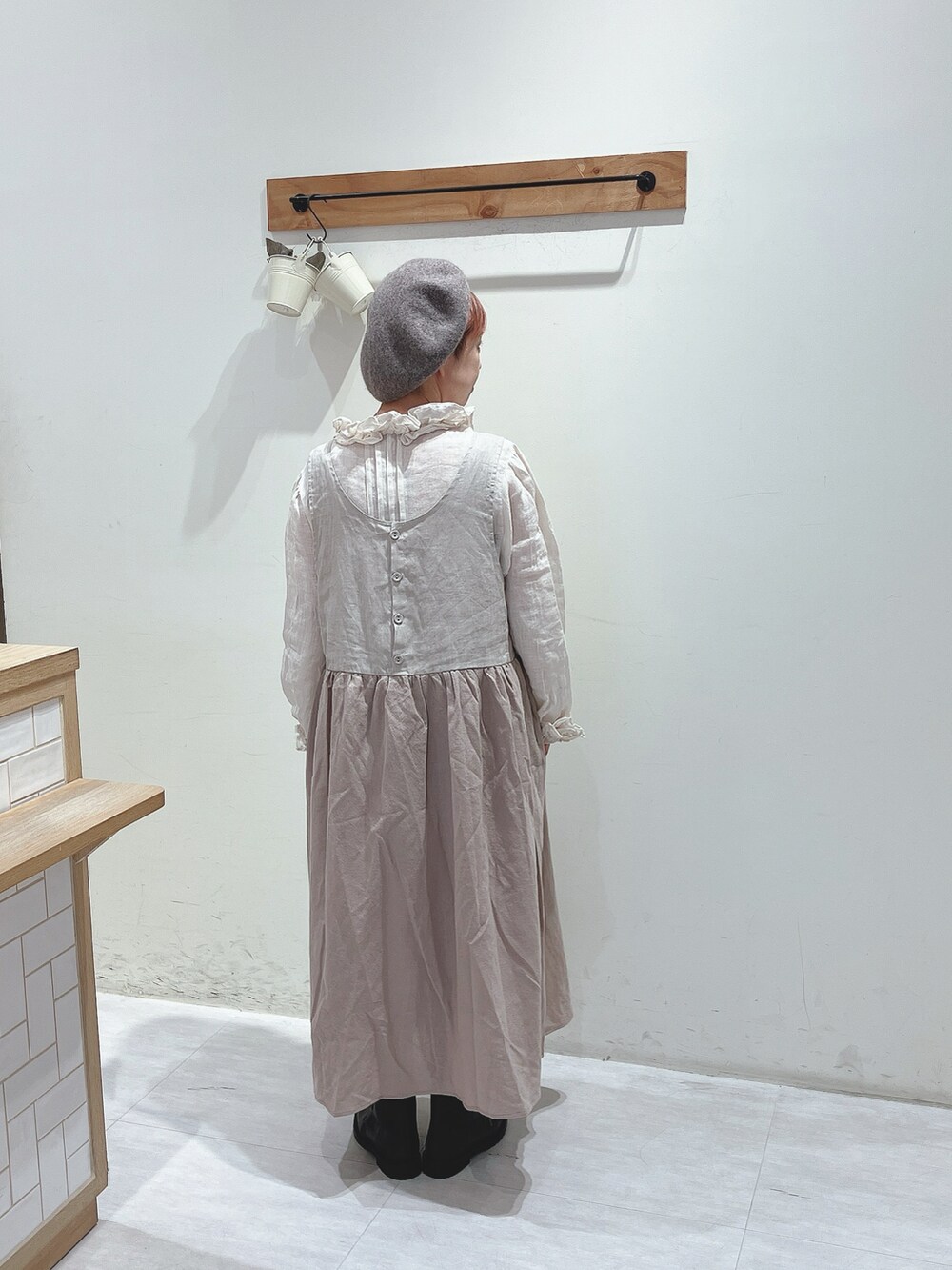 ベージュ系のワンピース、ホワイト系のシャツ/ブラウス、ブラック系のブーツを着用したレディースの秋コーディネートの3枚目の写真