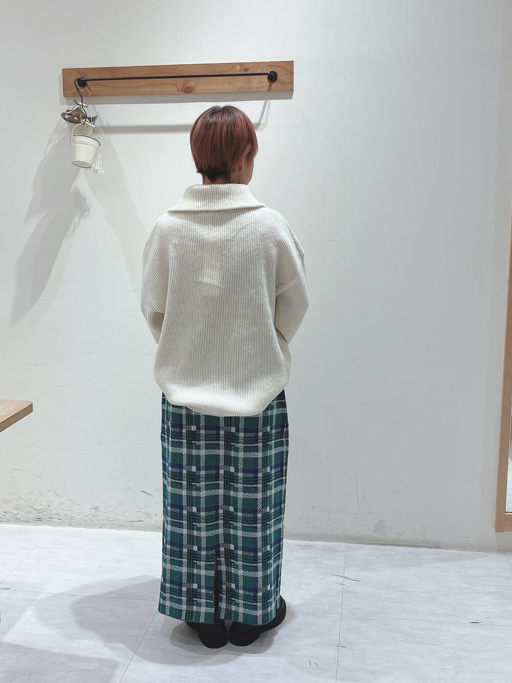 ホワイト系のニット/セーター、グリーン系のスカート、ブラック系のブーツを着用したレディースの秋コーディネートの3枚目の写真