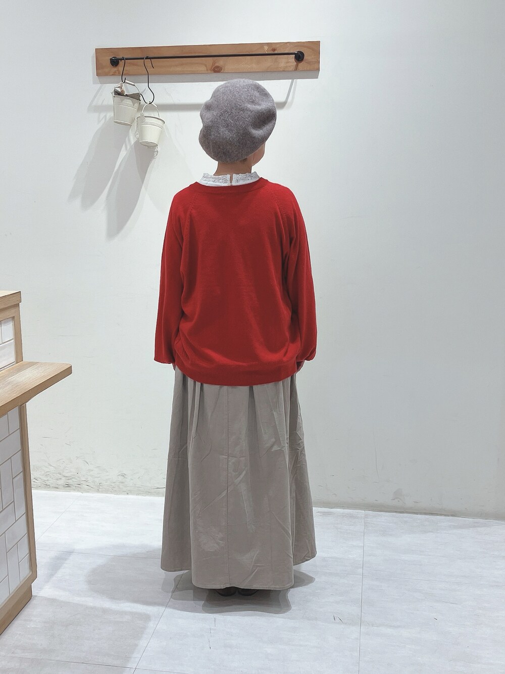 ホワイト系のTシャツ/カットソー、レッド系のカーディガン/ボレロ、ベージュ系のスカートを着用したレディースの秋コーディネートの3枚目の写真