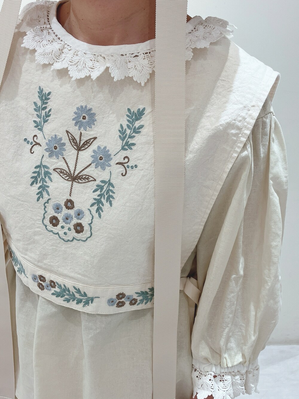 ホワイト系のベスト、ホワイト系のスカート、シルバー系のサンダルを着用したレディースの春コーディネートの4枚目の写真