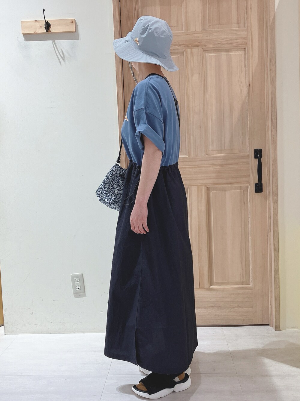 ブルー系のワンピース、ブルー系のショルダーバッグ、ブラック系のサンダルを着用したレディースの春コーディネートの2枚目の写真