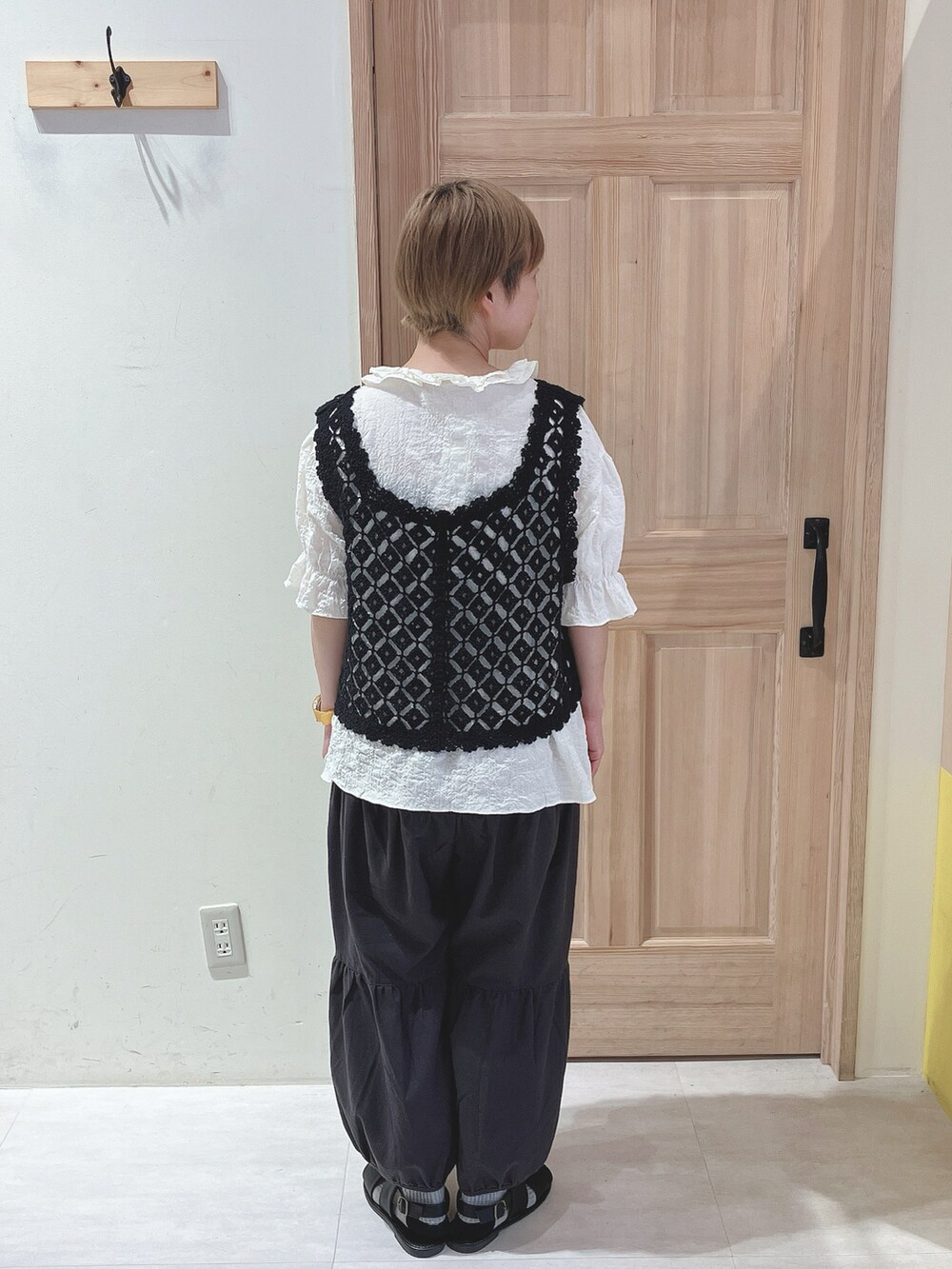 ブラック系のベスト、ホワイト系のシャツ/ブラウス、ブラック系のパンツを着用したレディースの夏コーディネートの3枚目の写真