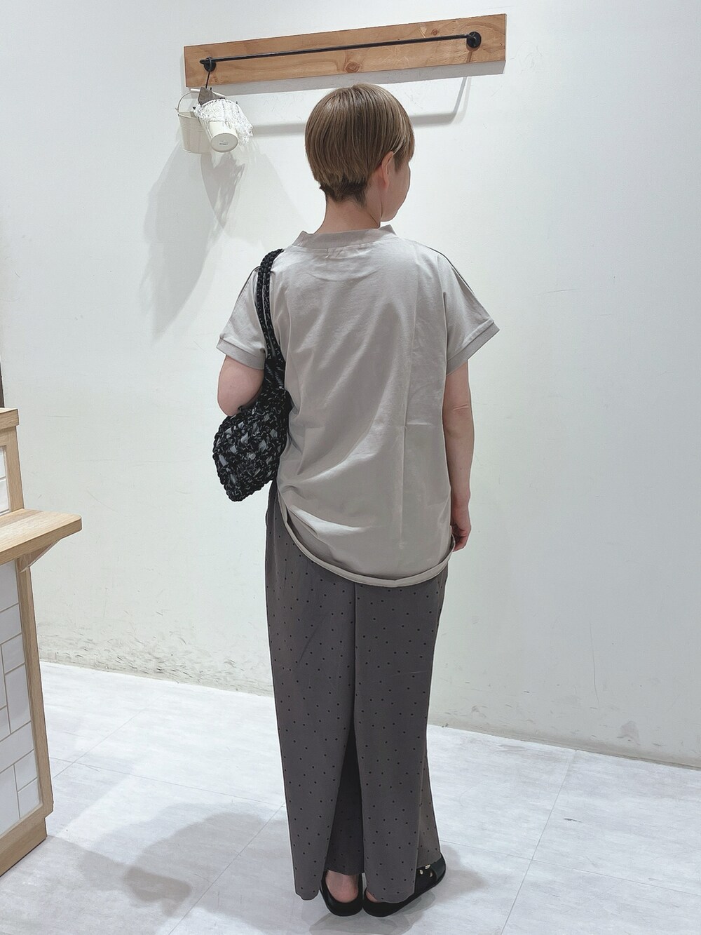 ベージュ系のTシャツ/カットソー、ブラック系のハンドバッグ、グレー系のその他パンツを着用したレディースの春コーディネートの3枚目の写真