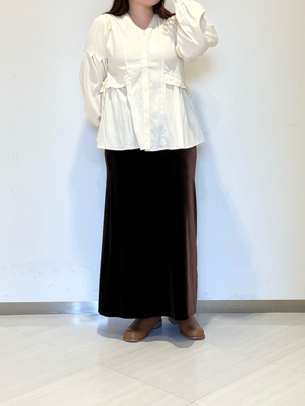 ブラウン系のスカート、イエロー系のシャツ/ブラウス、ブラウン系のブーツを着用したレディースの秋コーディネートの2枚目の写真