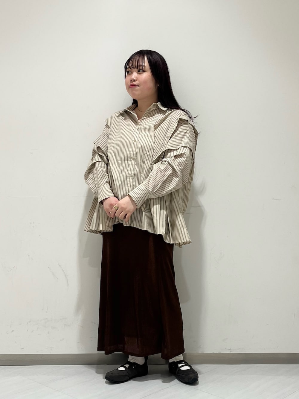 ベージュ系のシャツ/ブラウス、ブラウン系のスカート、ブラック系のボストンバッグを着用したレディースの冬コーディネートの2枚目の写真