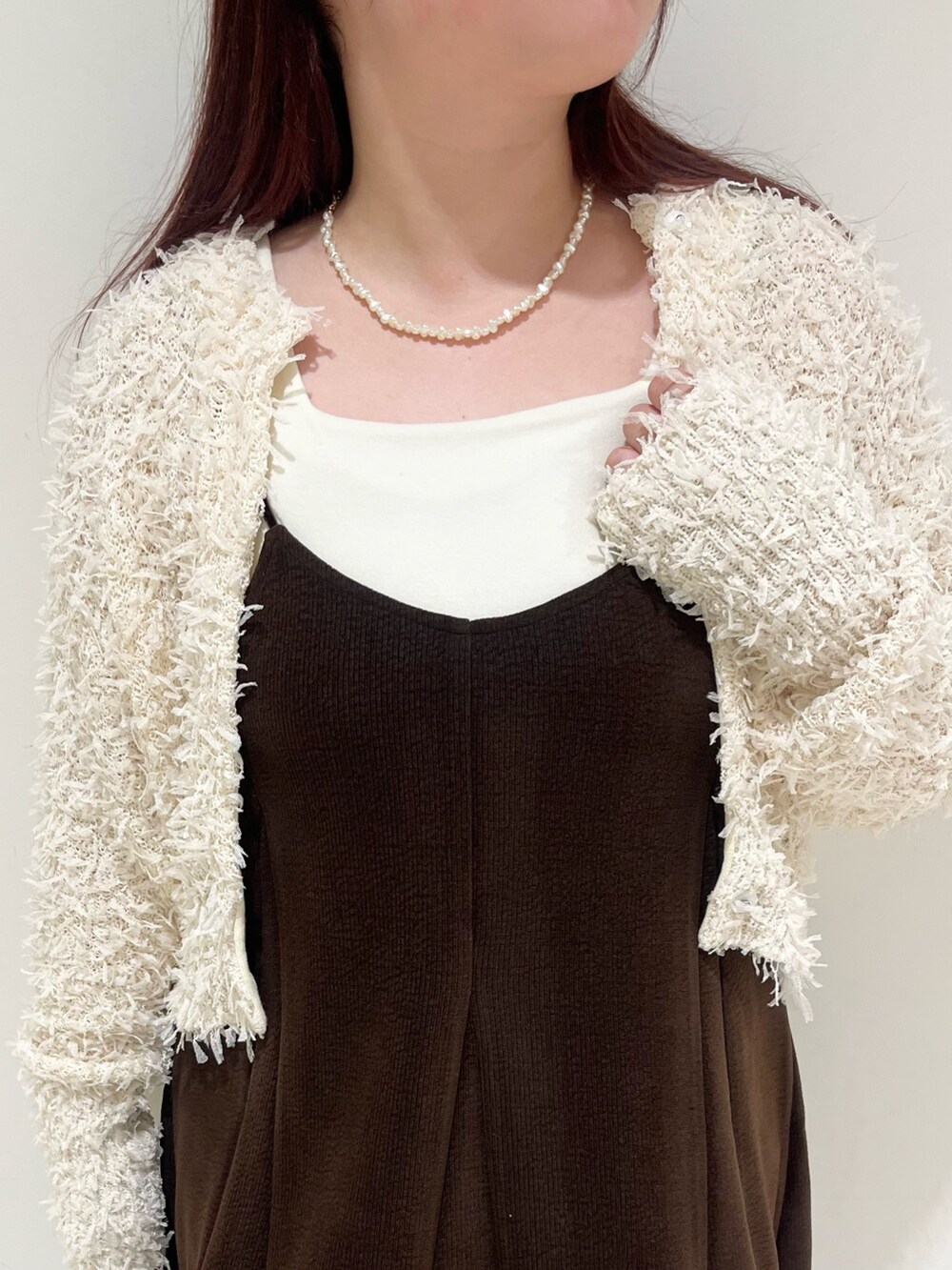 ブラウン系のワンピース、ブラック系のショルダーバッグ、ホワイト系のニット/セーターを着用したレディースの秋コーディネートの4枚目の写真