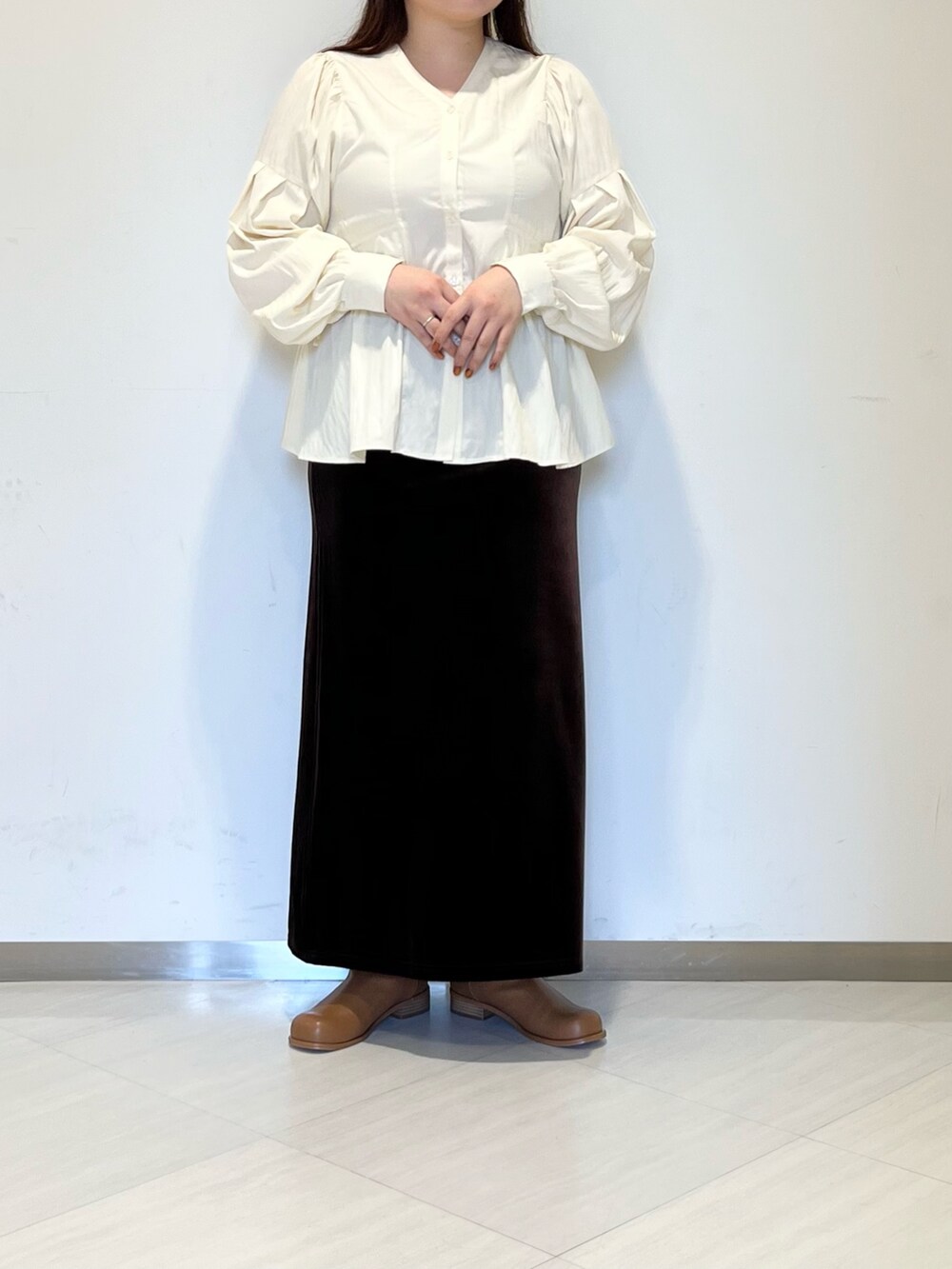 ブラウン系のスカート、イエロー系のシャツ/ブラウス、ブラウン系のブーツを着用したレディースの秋コーディネートの3枚目の写真