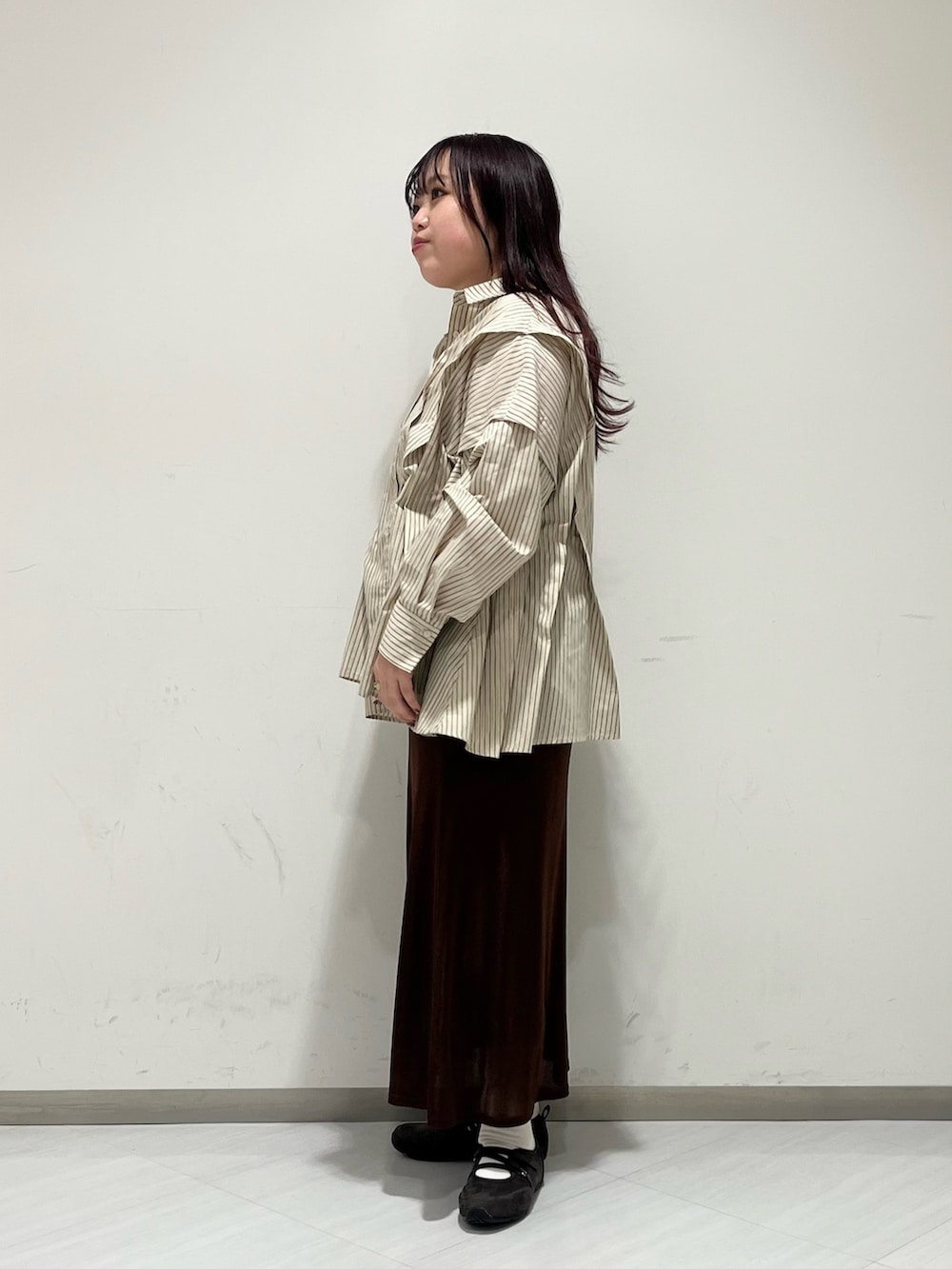 ベージュ系のシャツ/ブラウス、ブラウン系のスカート、ブラック系のボストンバッグを着用したレディースの冬コーディネートの3枚目の写真