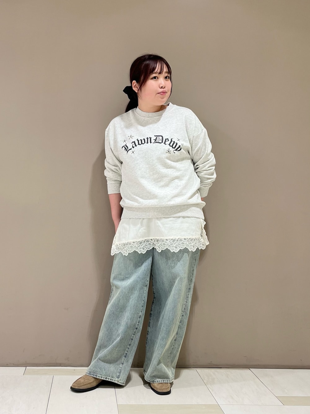 ホワイト系のキャミソール、グリーン系のブルゾン、ブルー系のデニムパンツを着用したレディースの冬コーディネートの3枚目の写真