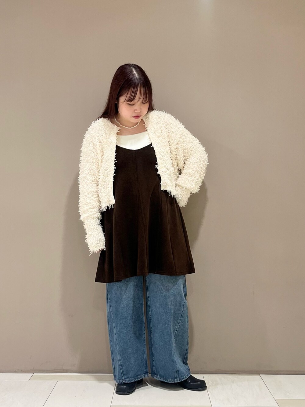 ブラウン系のワンピース、ブラック系のショルダーバッグ、ホワイト系のニット/セーターを着用したレディースの秋コーディネートの3枚目の写真