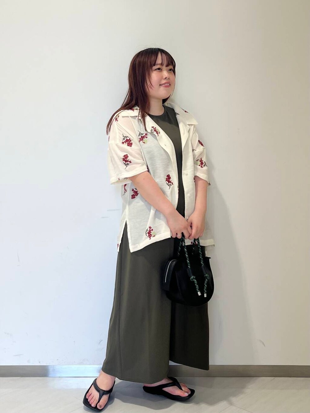 ホワイト系のシャツ/ブラウス、グリーン系のワンピース、ブラック系のハンドバッグを着用したレディースの夏コーディネートの2枚目の写真