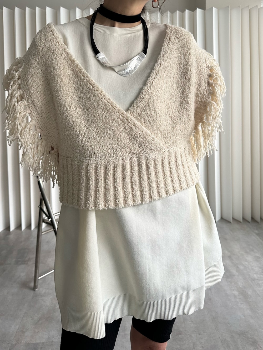 ベージュ系のベスト、ブラック系のスニーカー、ブラック系のレギンス/スパッツを着用したレディースの冬コーディネートの4枚目の写真