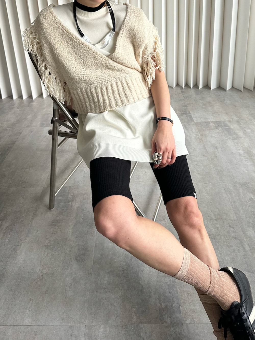 ベージュ系のベスト、ブラック系のスニーカー、ブラック系のレギンス/スパッツを着用したレディースの冬コーディネートの3枚目の写真