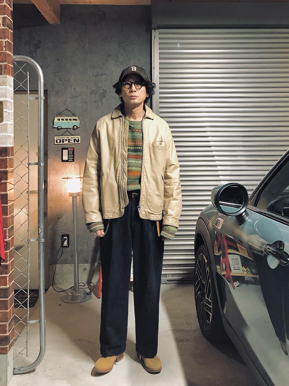 ブルー系のデニムパンツ、ベージュ系のその他アウター、ブラウン系のメガネを着用したメンズの冬コーディネートの2枚目の写真