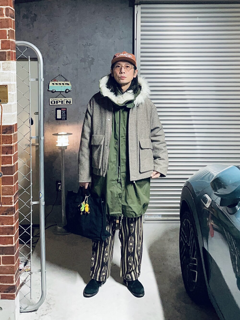 ブラック系のブーツ、グリーン系のモッズコート、ベージュ系のその他アウターを着用したメンズの冬コーディネートの2枚目の写真