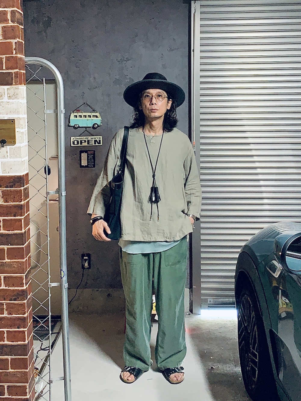 ブラック系のトートバッグ、グリーン系のその他パンツ、その他のその他トップスを着用したメンズの夏コーディネートの2枚目の写真