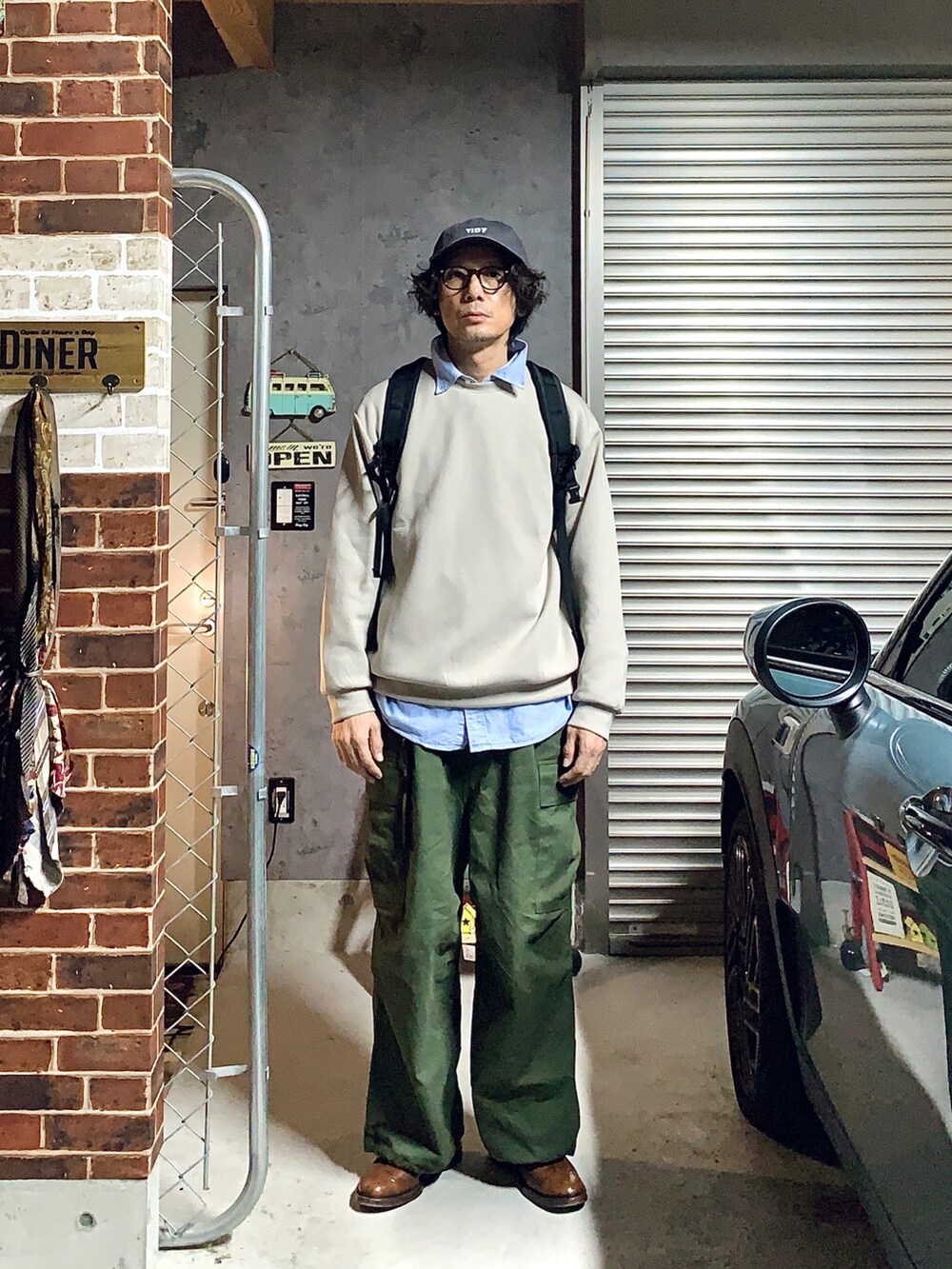 ブラウン系のドレスシューズ、グリーン系のカーゴパンツ、グレー系のスウェットを着用したメンズの秋コーディネートの2枚目の写真