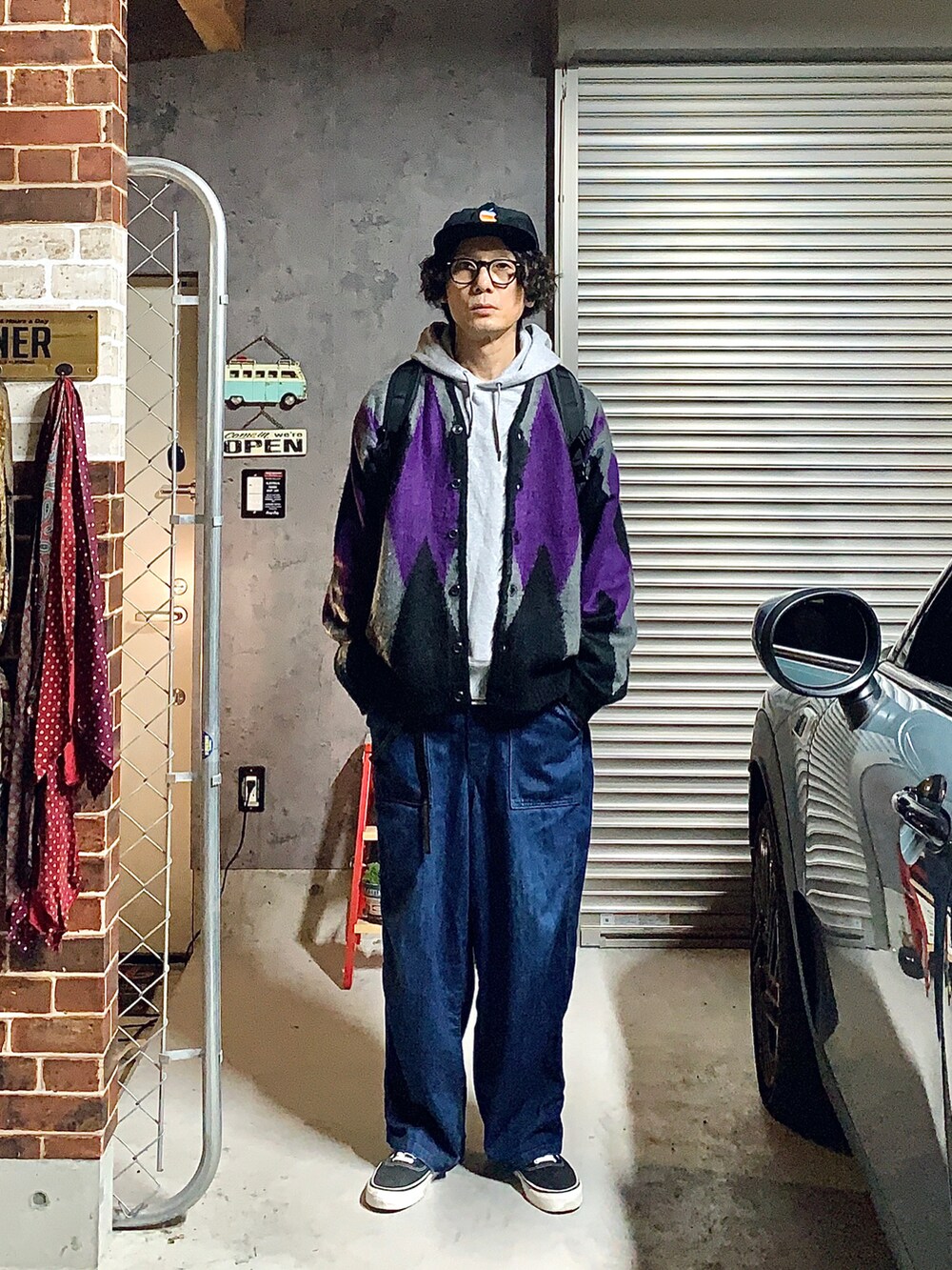 ブルー系のデニムパンツ、グレー系のカーディガン/ボレロ、ブラック系のスニーカーを着用したメンズの秋コーディネートの2枚目の写真