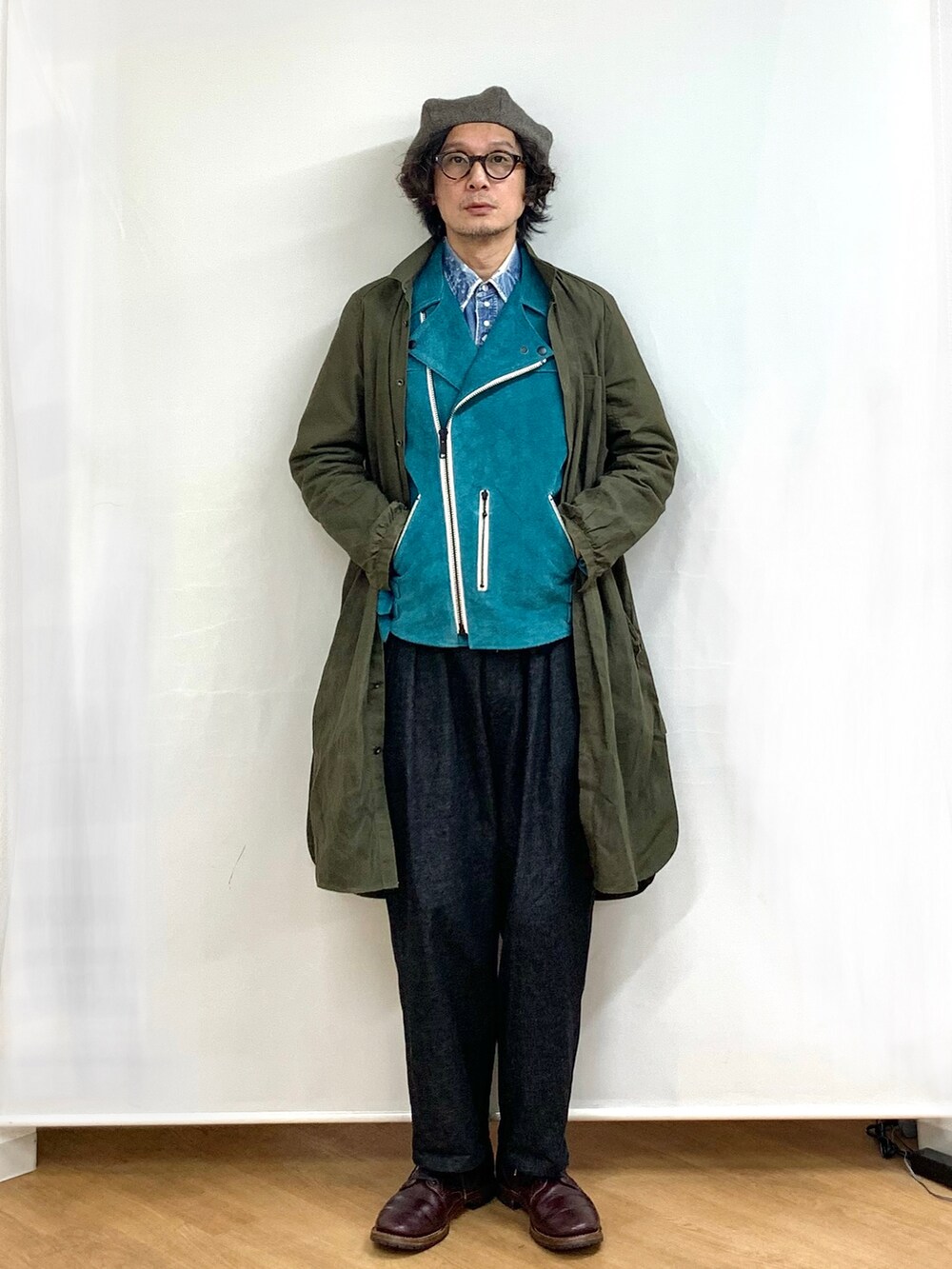 ブラック系のデニムパンツ、レッド系のブーツ、グリーン系のその他アウターを着用したメンズの冬コーディネートの2枚目の写真