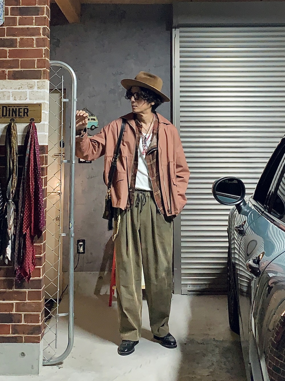 ピンク系のその他アウター、ベージュ系のその他パンツ、ブラック系のハットを着用したメンズの秋コーディネートの2枚目の写真