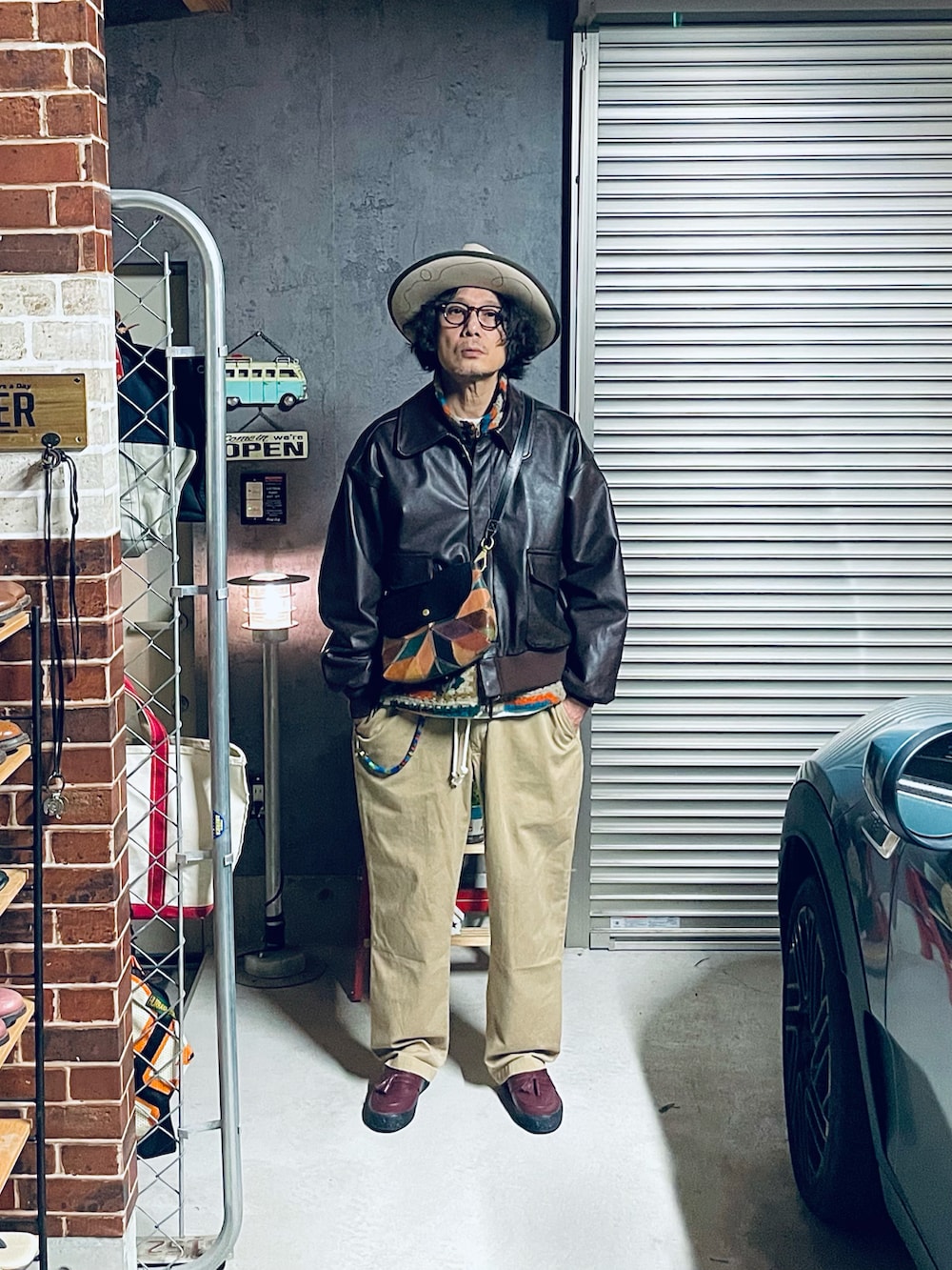 その他のベスト、ブラウン系のミリタリージャケット、ベージュ系のチノパンツを着用したメンズの冬コーディネートの2枚目の写真