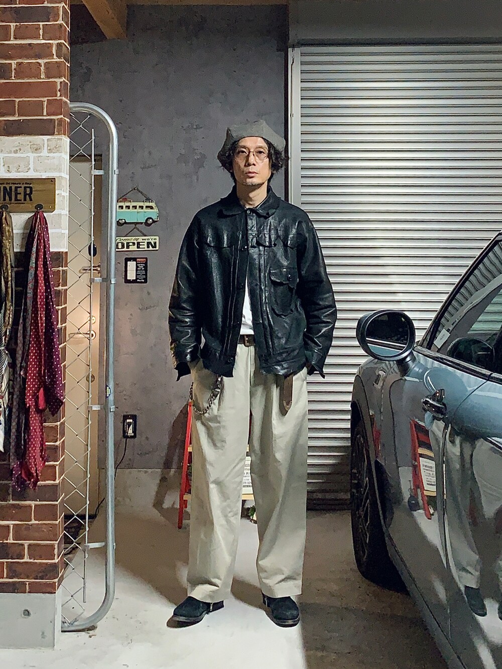 ブラック系のその他アウター、ブラック系のブーツ、ベージュ系のチノパンツを着用したメンズの秋コーディネートの2枚目の写真