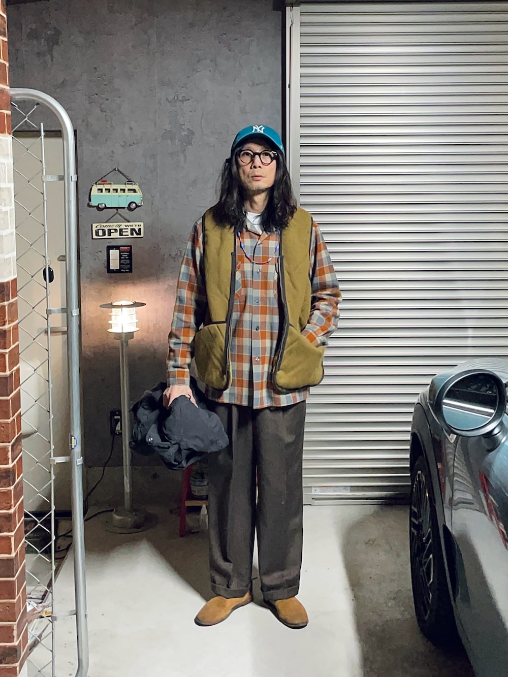 ブラウン系のスラックス、ブラウン系のその他シューズ、ブラック系のミリタリージャケットを着用したメンズの冬コーディネートの3枚目の写真