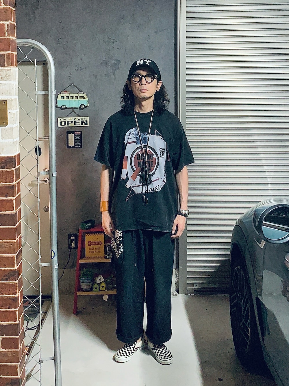 ブラック系のスリッポン、ブラック系のその他パンツ、ブラック系のTシャツ/カットソーを着用したメンズの夏コーディネートの4枚目の写真