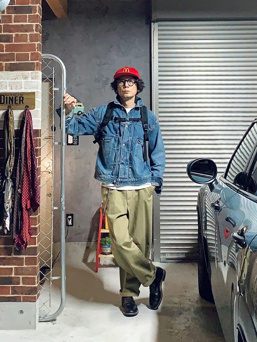 ブルー系のデニムジャケット、ブラック系のブーツ、ベージュ系のチノパンツを着用したメンズの秋コーディネートの2枚目の写真