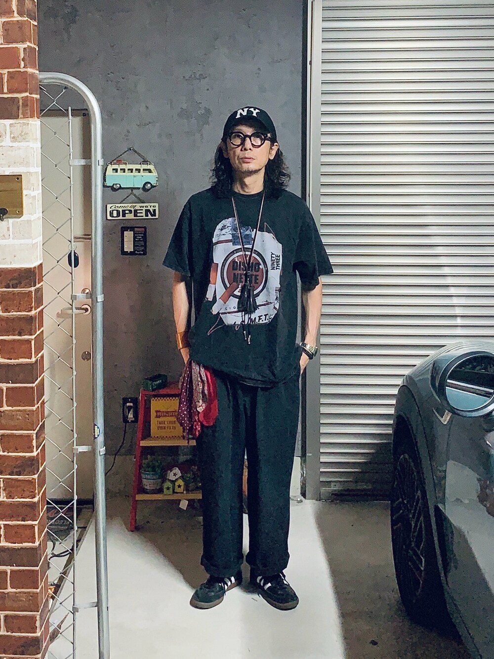 ブラック系のスリッポン、ブラック系のその他パンツ、ブラック系のTシャツ/カットソーを着用したメンズの夏コーディネートの5枚目の写真