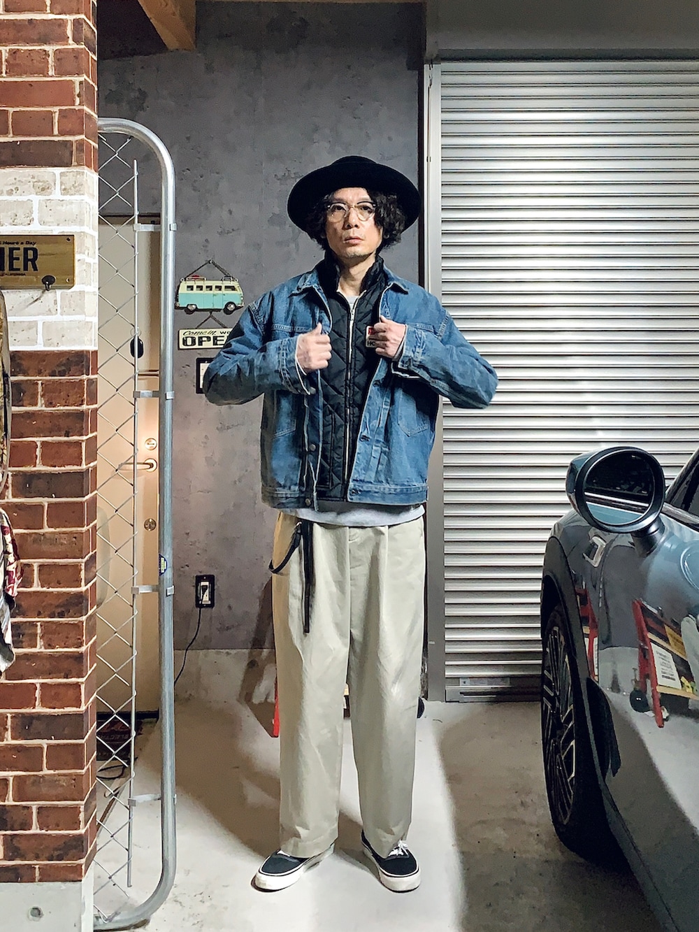 ベージュ系のチノパンツ、ブラック系のスニーカー、ブルー系のデニムジャケットを着用したメンズの秋コーディネートの2枚目の写真