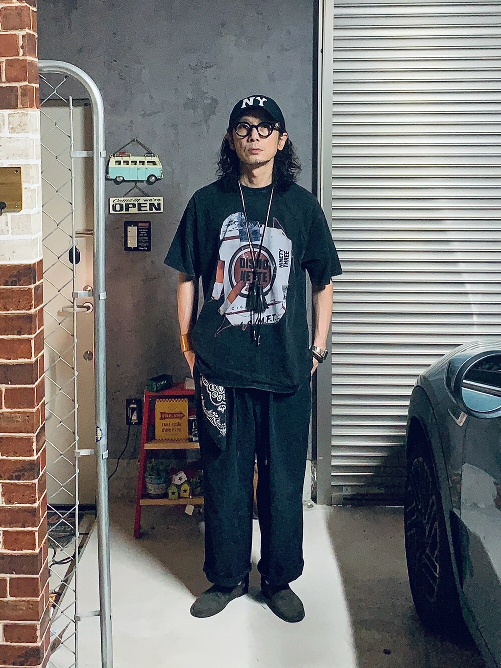 ブラック系のスリッポン、ブラック系のその他パンツ、ブラック系のTシャツ/カットソーを着用したメンズの夏コーディネートの2枚目の写真