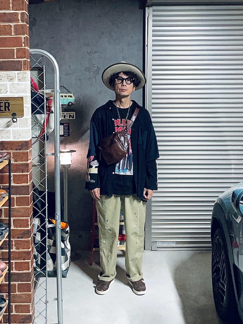 ブラック系のTシャツ/カットソー、ベージュ系のチノパンツ、ベージュ系のハットを着用したメンズの秋コーディネートの2枚目の写真
