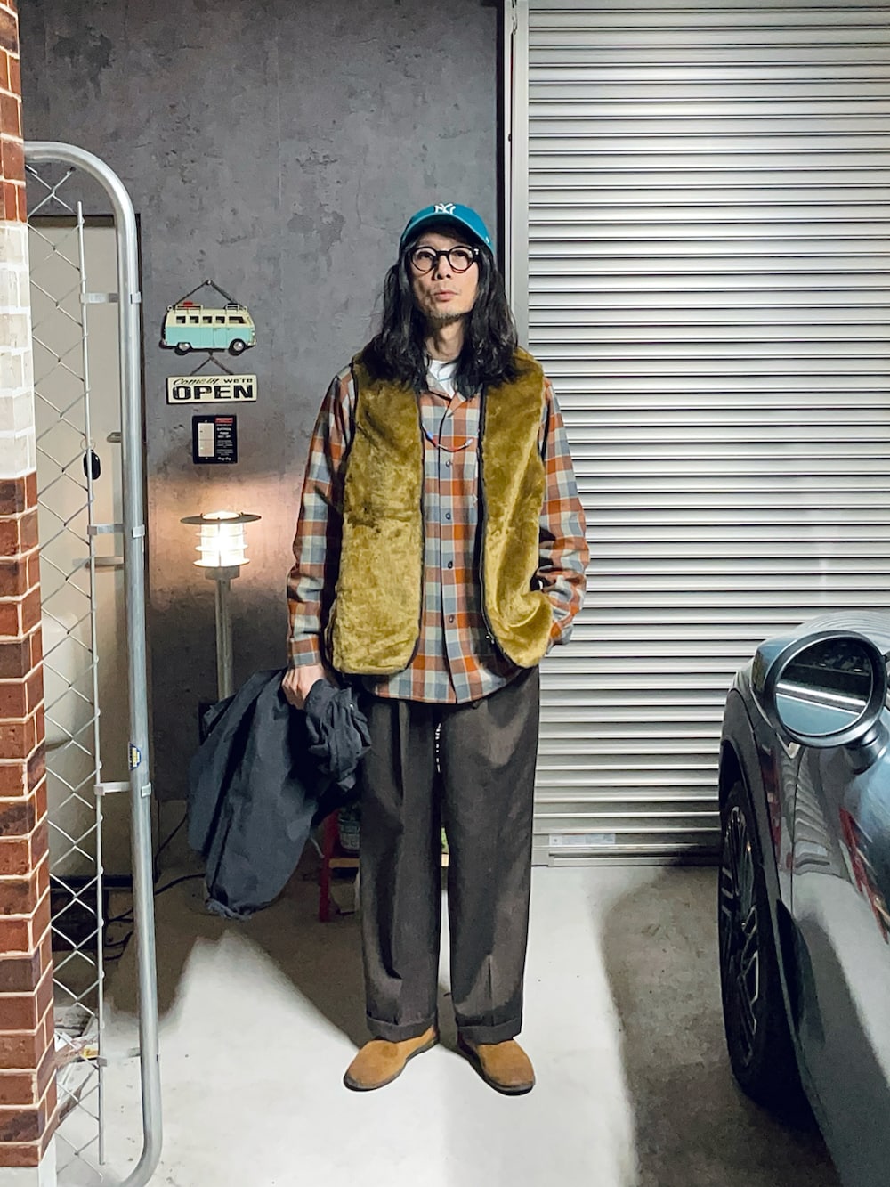 ブラウン系のスラックス、ブラウン系のその他シューズ、ブラック系のミリタリージャケットを着用したメンズの冬コーディネートの2枚目の写真