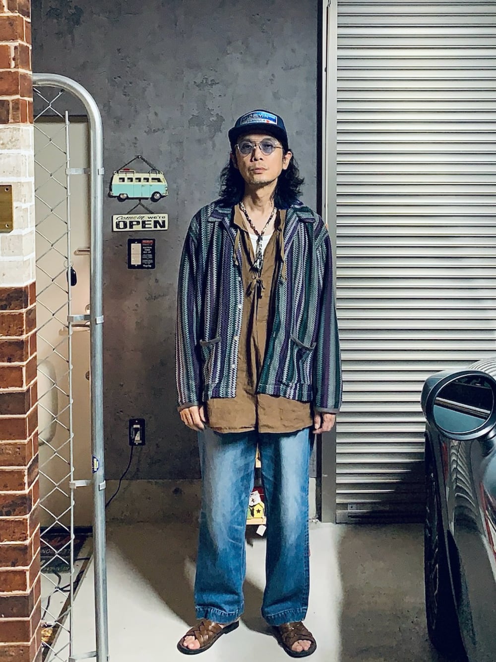 ブラック系のシャツ/ブラウス、ブルー系のデニムパンツ、シルバー系のサングラスを着用したメンズの夏コーディネートの2枚目の写真