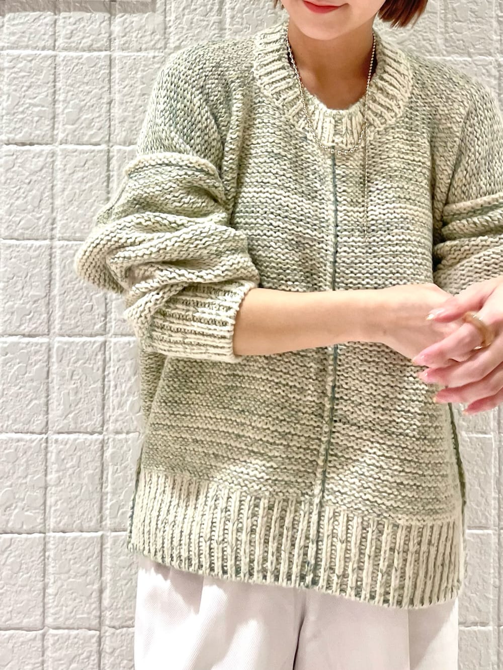 ベージュ系のニット/セーター、ホワイト系のその他パンツ、グリーン系のスニーカーを着用したレディースの秋コーディネートの2枚目の写真