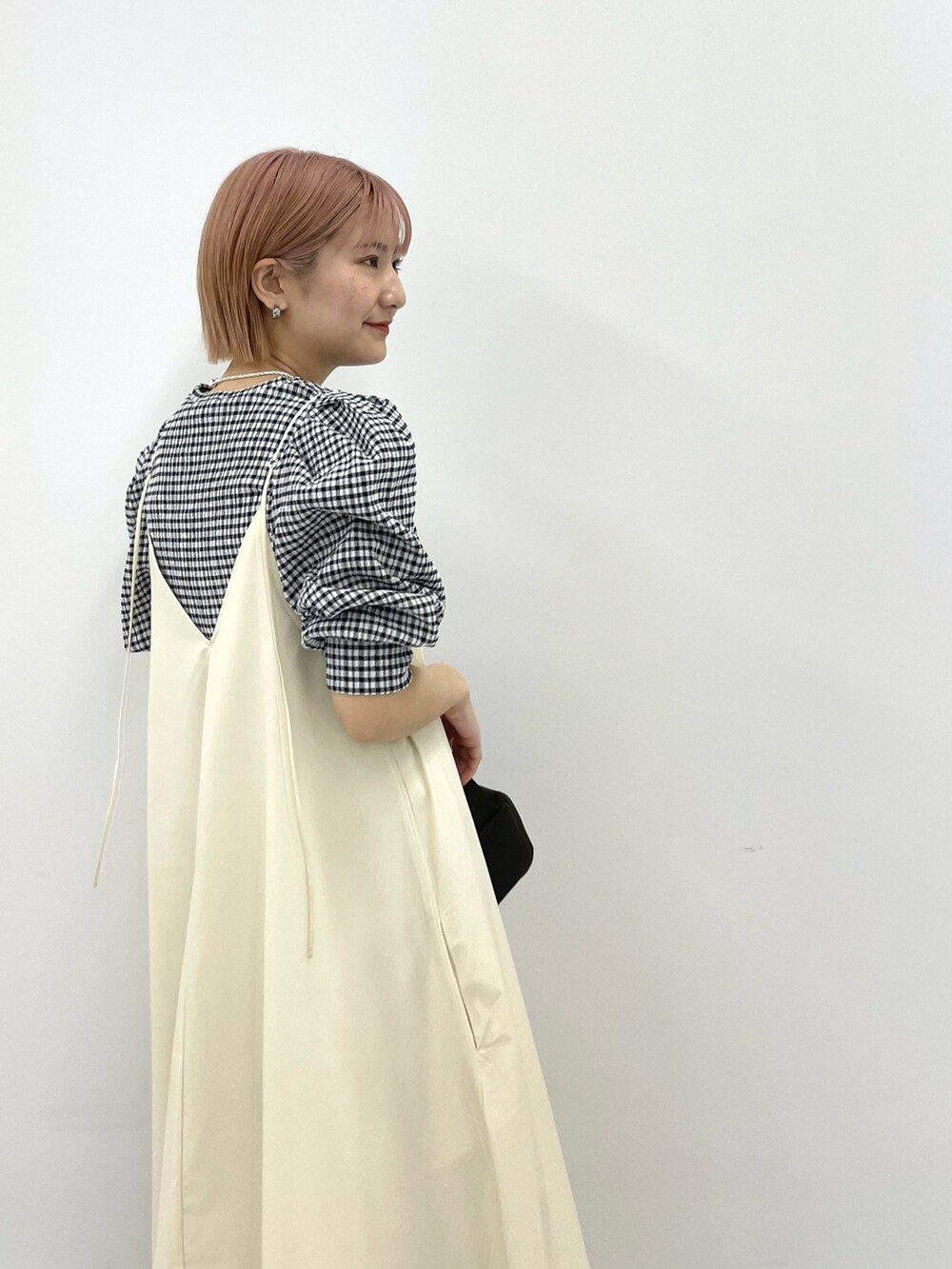 ホワイト系のワンピース、ブラウン系のハンドバッグ、ブラック系のシャツ/ブラウスを着用したレディースの春コーディネートの3枚目の写真